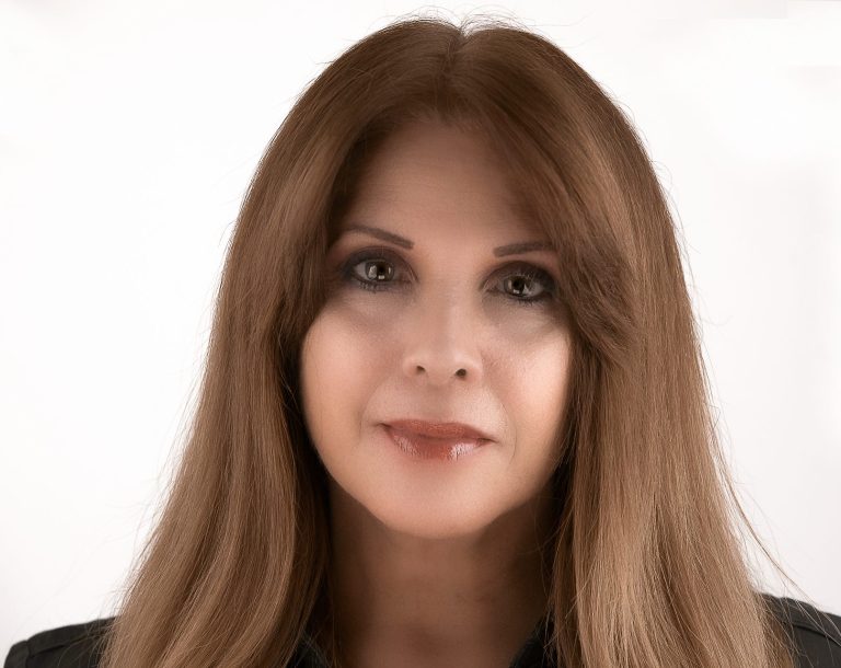 Iris Ramil a photographer in Miami posing with long, straight brown hair and a neutral expression at her photo studio in Pinecrest.