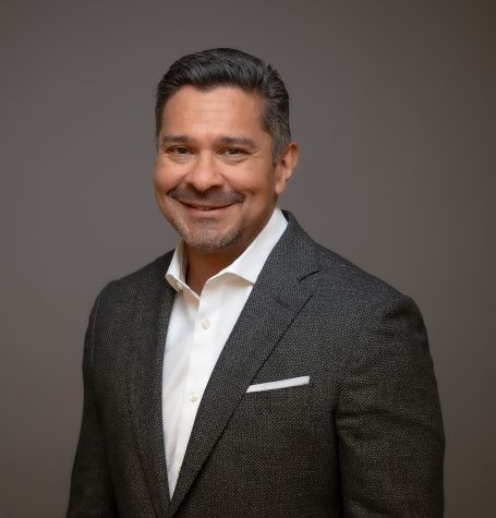 Executive man with gray suit and short dark hair, smiling at the camera for his headshot in Miami