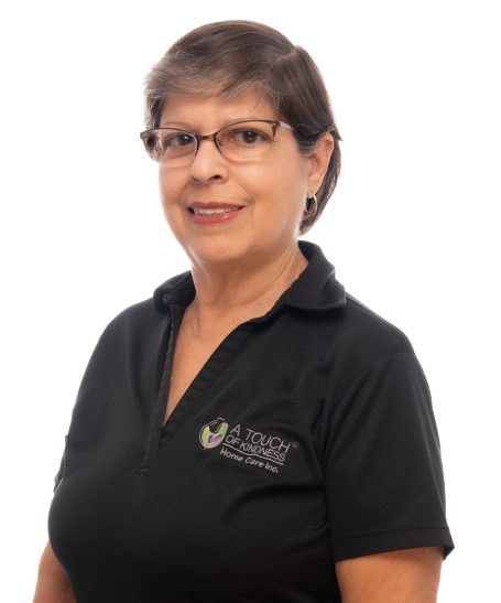 A nurse posing at Headshot Studio Portraits in Miami for her headshot in uniform and smiling