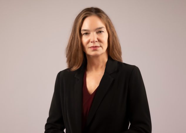 An executive woman with brown hair wearing a black blazer at her headshot session in Miami